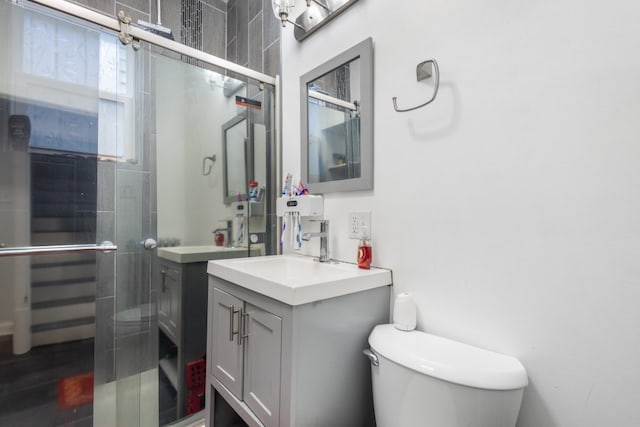 full bathroom with toilet, a shower stall, and vanity