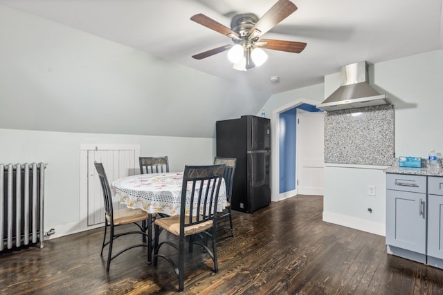 dining space with lofted ceiling, ceiling fan, dark wood-style flooring, baseboards, and radiator