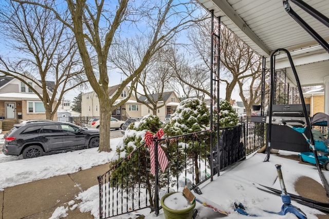 snow covered patio with a residential view