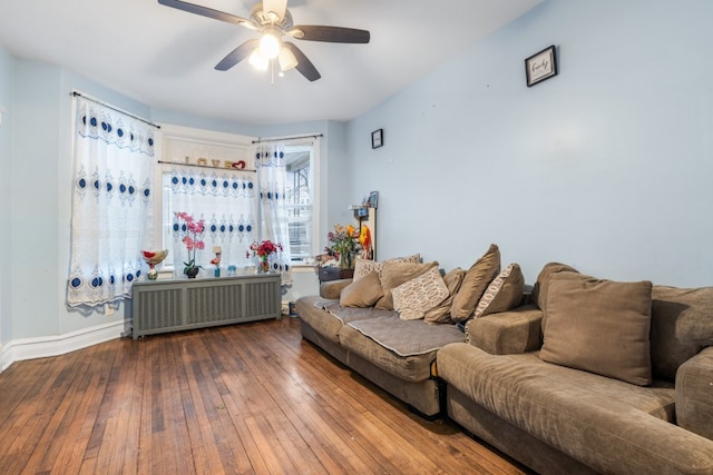 living area with ceiling fan, radiator heating unit, wood finished floors, and baseboards