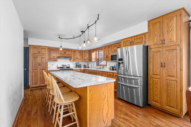 4461 N Il State Route 23, Leland, IL 60531 - kitchen with wood finished floors, a sink, light countertops, appliances with stainless steel finishes, and a center island