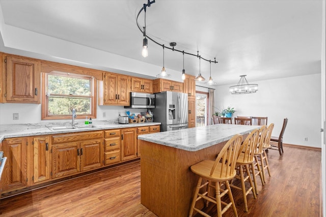 4461 N Il State Route 23, Leland, IL 60531 - kitchen featuring light wood-style flooring, a kitchen island, appliances with stainless steel finishes, and a sink