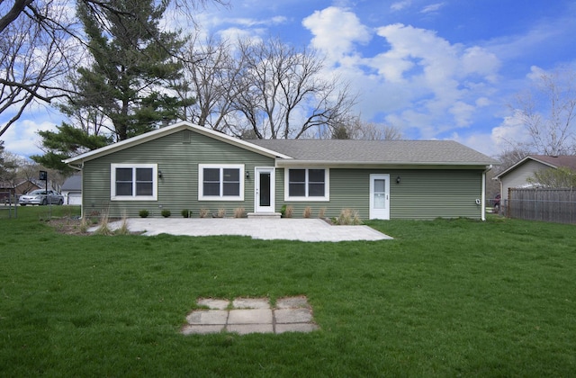 back of house featuring a patio area, roof with shingles, fence, and a yard