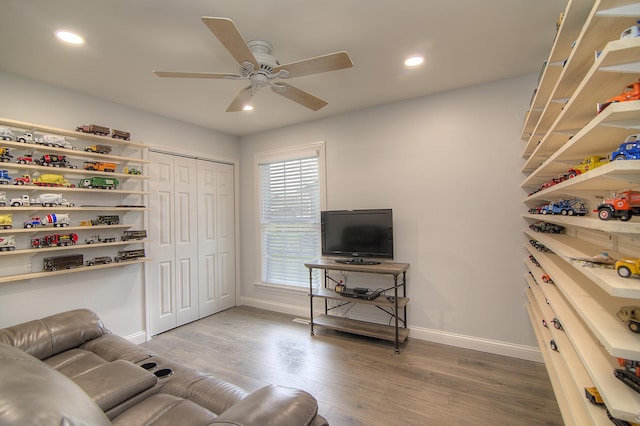 living area featuring baseboards, wood finished floors, and recessed lighting