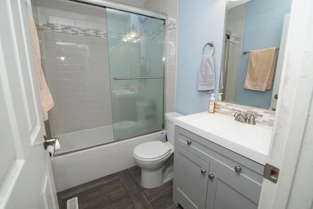 bathroom featuring visible vents, decorative backsplash, toilet, enclosed tub / shower combo, and vanity