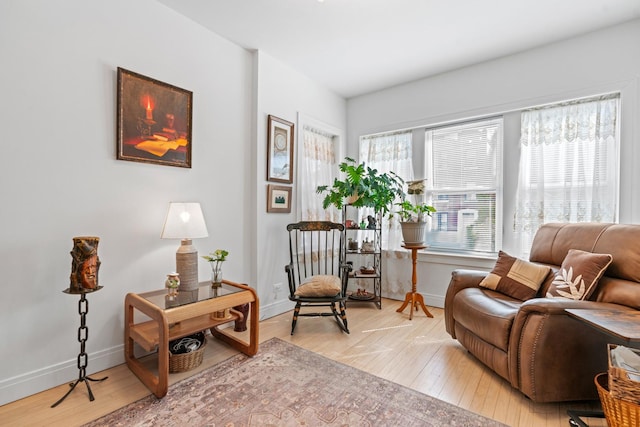 living area with light wood-type flooring and baseboards