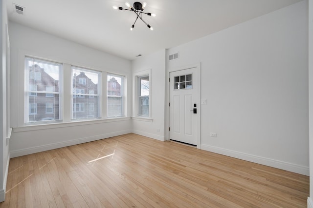 foyer entrance featuring light wood-style floors, visible vents, and baseboards