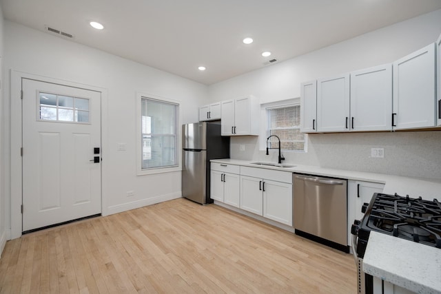 kitchen featuring recessed lighting, a sink, visible vents, appliances with stainless steel finishes, and light wood finished floors