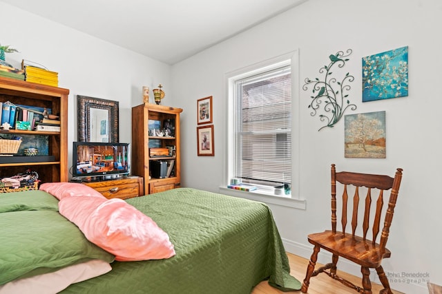 bedroom featuring wood finished floors and baseboards