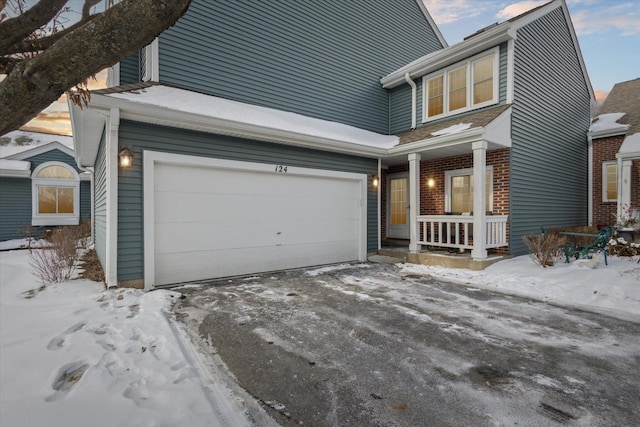 view of front of property with a garage, covered porch, and brick siding