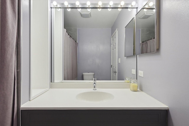 bathroom featuring toilet, curtained shower, and vanity