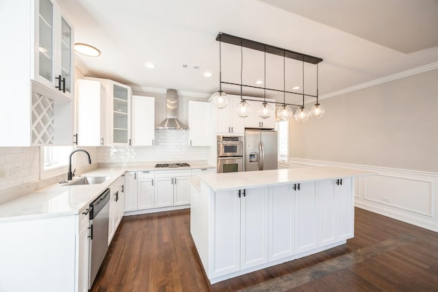 kitchen featuring stainless steel appliances, glass insert cabinets, white cabinetry, a kitchen island, and wall chimney exhaust hood