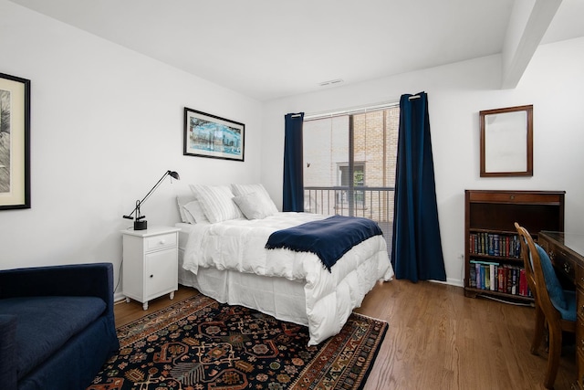 bedroom with visible vents and wood finished floors