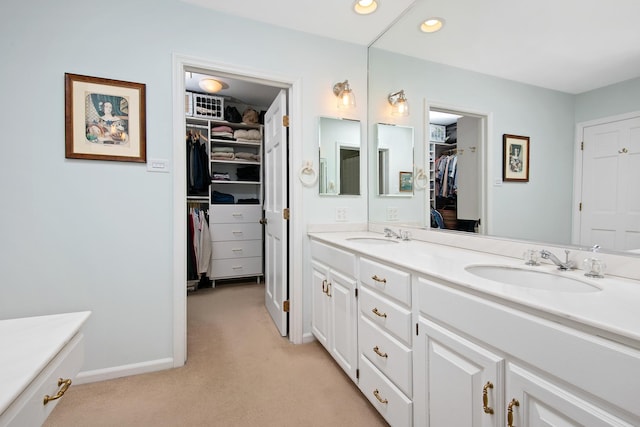 bathroom featuring recessed lighting, carpet flooring, a sink, and double vanity