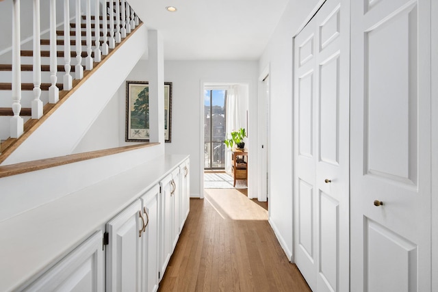 hallway with recessed lighting, dark wood-style flooring, and stairs