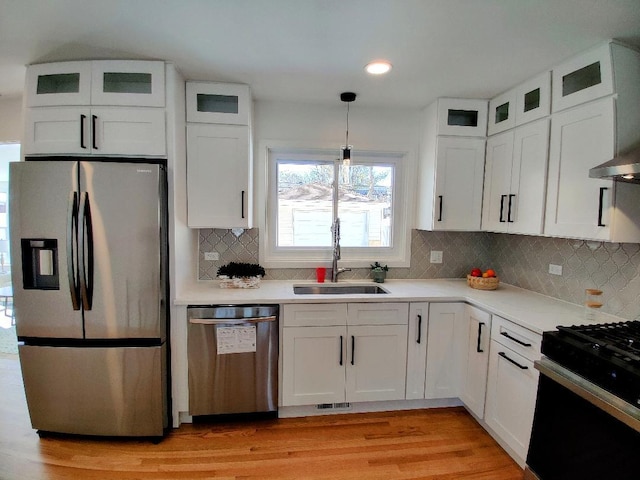 kitchen with light countertops, appliances with stainless steel finishes, a sink, and white cabinets