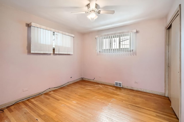 unfurnished bedroom featuring light wood finished floors, a closet, visible vents, and a ceiling fan