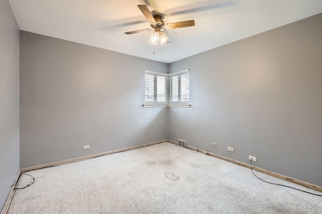 empty room with a ceiling fan, baseboards, visible vents, and carpet flooring