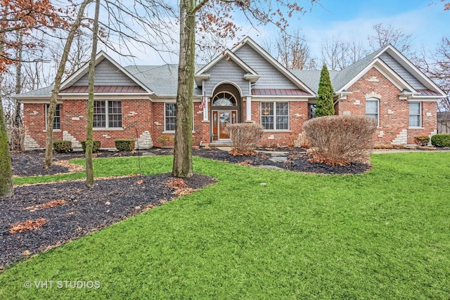 view of front of house featuring brick siding, a front lawn, and roof with shingles