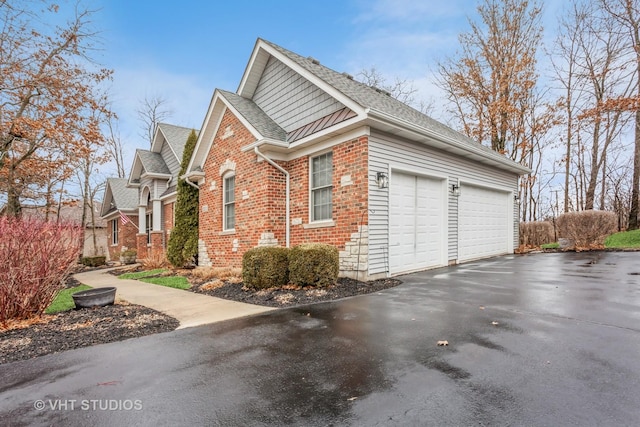 view of side of home with brick siding, an attached garage, aphalt driveway, and roof with shingles