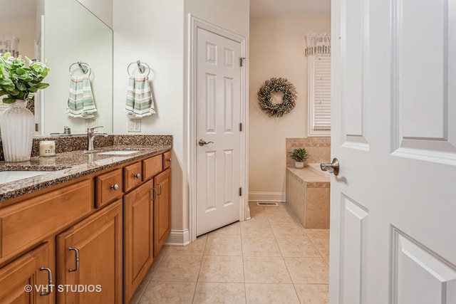 full bathroom featuring tile patterned flooring, visible vents, tiled tub, double vanity, and a sink