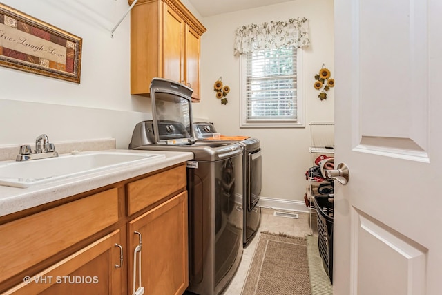 laundry room with visible vents, a sink, cabinet space, baseboards, and washing machine and clothes dryer