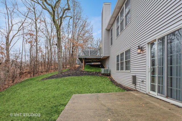 view of yard featuring a patio, central air condition unit, and a wooden deck