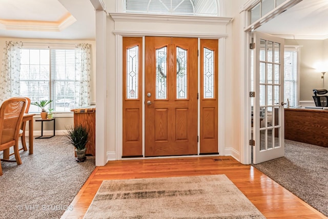 entryway with ornamental molding, french doors, baseboards, and wood finished floors