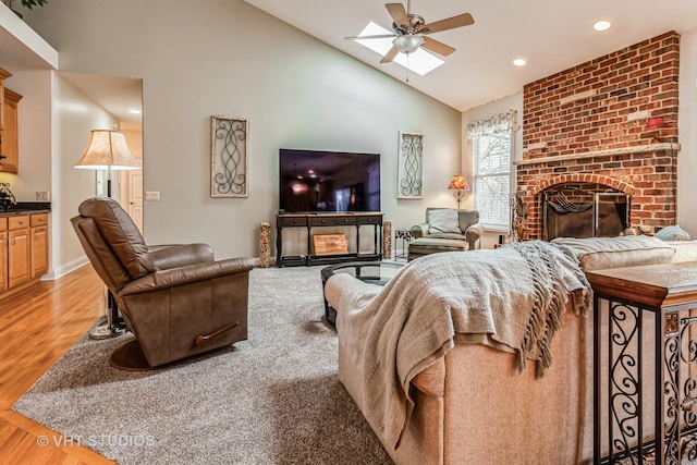 living room featuring light wood finished floors, a brick fireplace, recessed lighting, high vaulted ceiling, and a ceiling fan