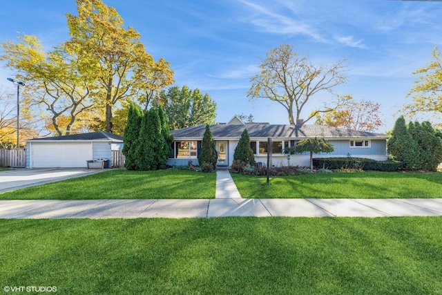 ranch-style home with a detached garage, fence, an outbuilding, and a front yard