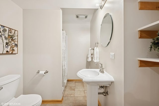 bathroom with visible vents, toilet, a shower with curtain, baseboards, and tile patterned floors