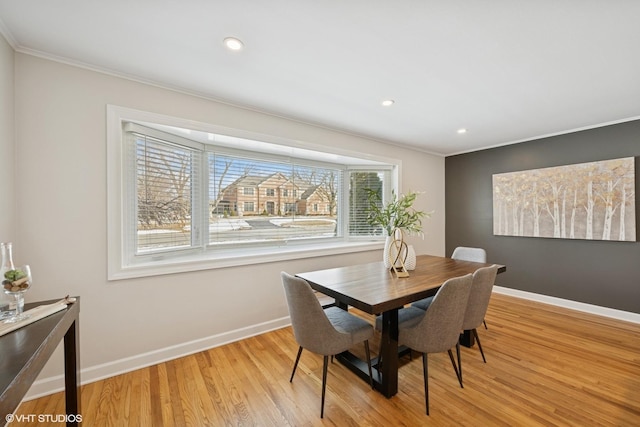 dining room featuring ornamental molding, light wood-type flooring, baseboards, and recessed lighting