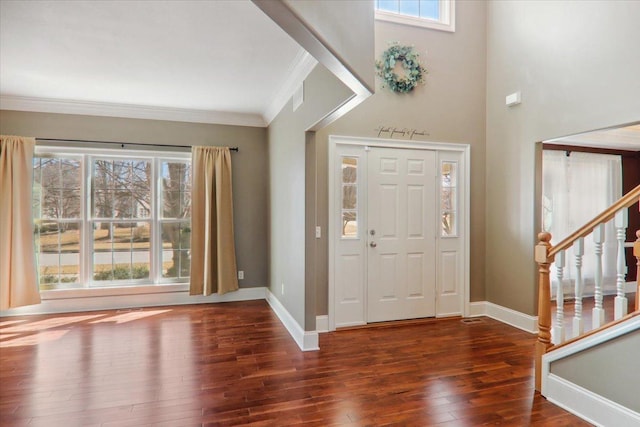 entryway featuring wood-type flooring, stairs, baseboards, and crown molding