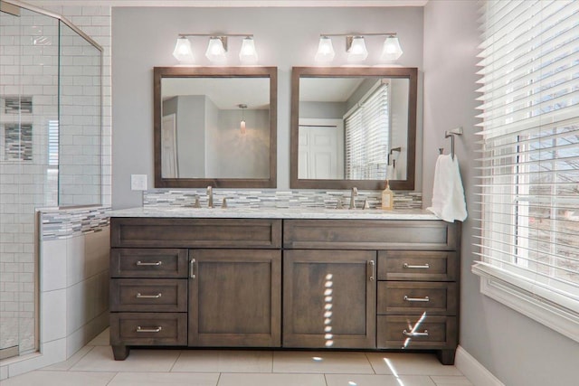 full bathroom with a sink, tile patterned flooring, double vanity, and tiled shower