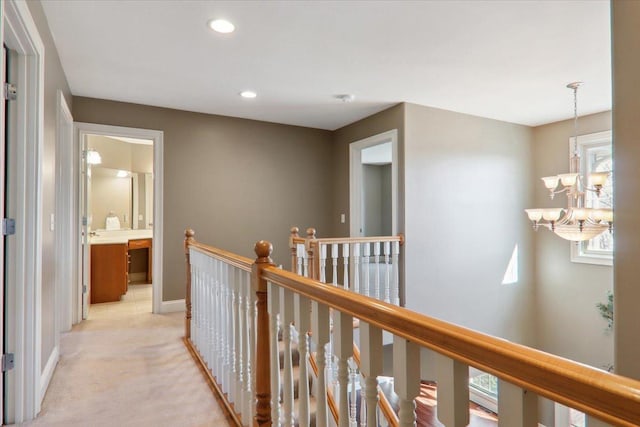 hallway featuring recessed lighting, light carpet, a notable chandelier, an upstairs landing, and baseboards