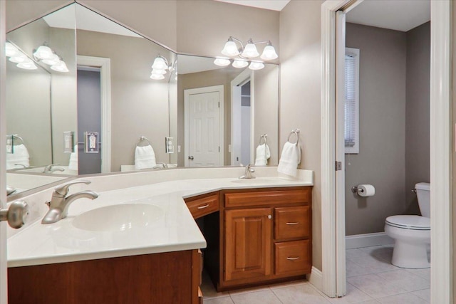 bathroom with double vanity, toilet, a sink, and tile patterned floors