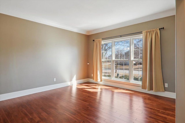 unfurnished room featuring ornamental molding, wood finished floors, and baseboards