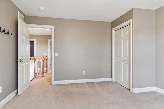 bedroom with baseboards, a closet, visible vents, and light colored carpet