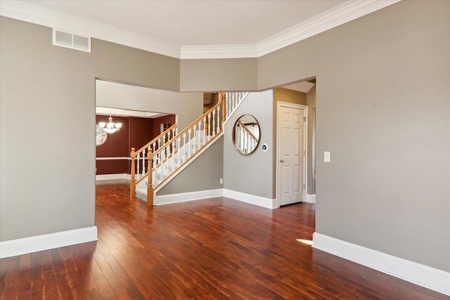 empty room with visible vents, baseboards, hardwood / wood-style floors, stairs, and crown molding