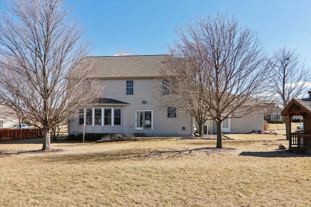 back of house with a yard and fence