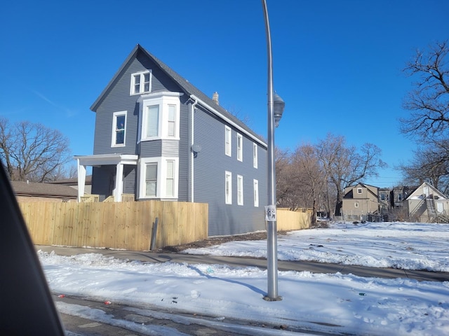 view of snow covered exterior featuring fence