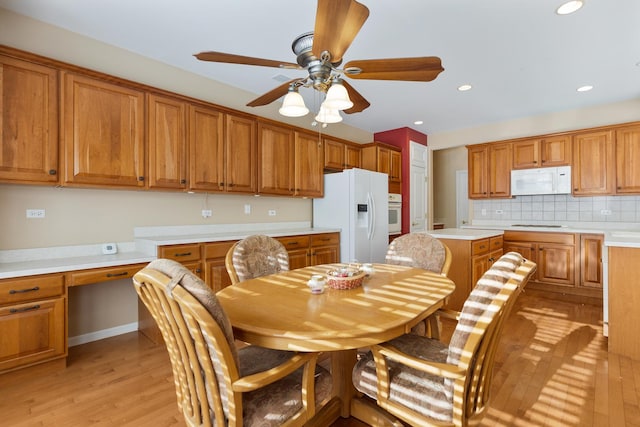 dining area featuring built in desk, light wood-style floors, a ceiling fan, and recessed lighting