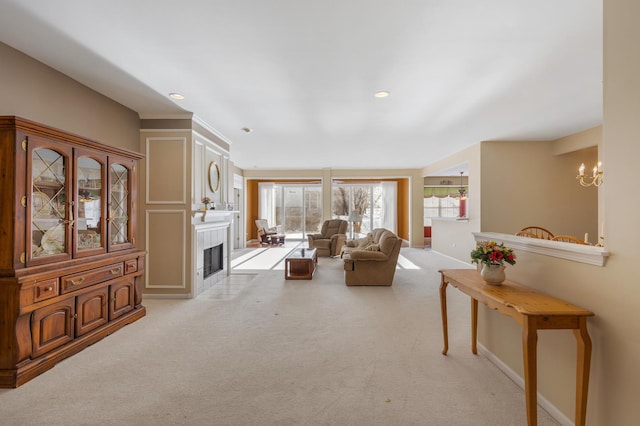 living area featuring light carpet, a fireplace with flush hearth, and baseboards