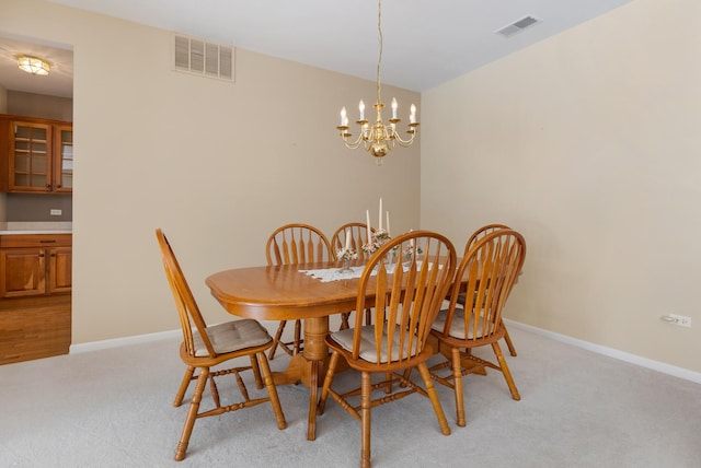 dining room with baseboards, visible vents, and light colored carpet