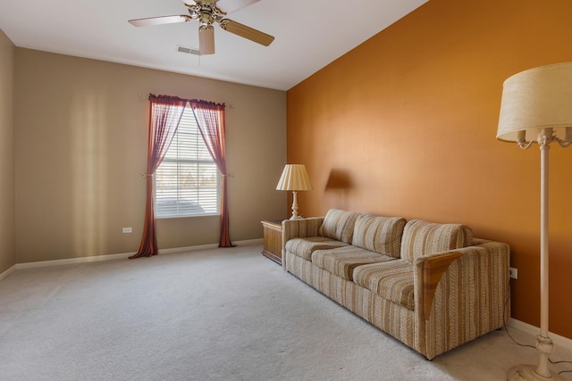 carpeted living area featuring ceiling fan and baseboards