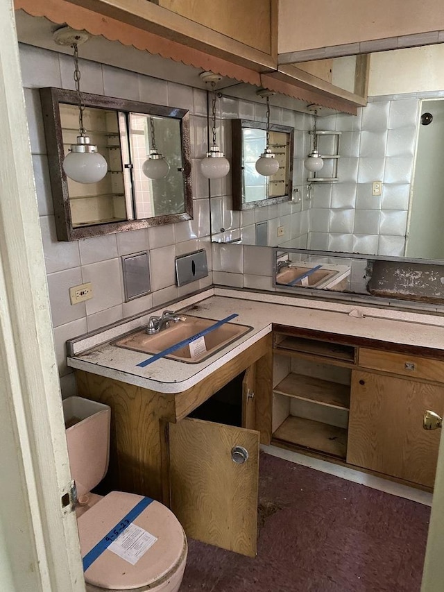 kitchen with hanging light fixtures, brown cabinets, light countertops, and decorative backsplash