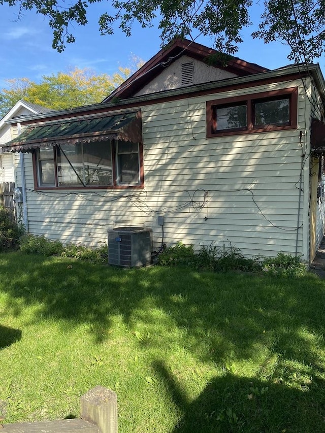 view of side of property with a yard and central AC unit