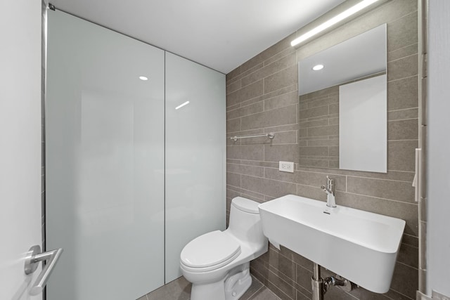 full bath with toilet, a sink, tile walls, and recessed lighting