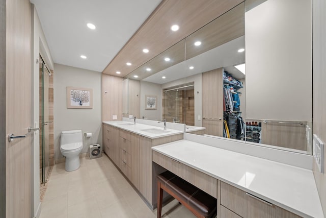 bathroom with toilet, recessed lighting, a sink, a spacious closet, and double vanity