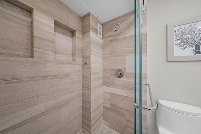 bathroom with toilet and a shower stall